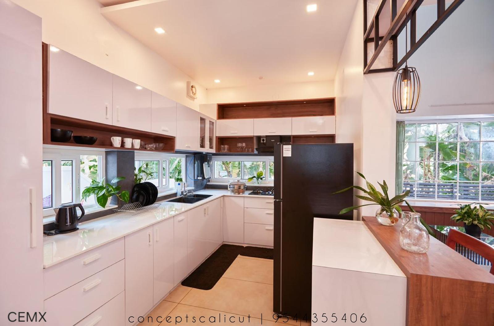 Open kitchen with handle-less white shutters and timber counter