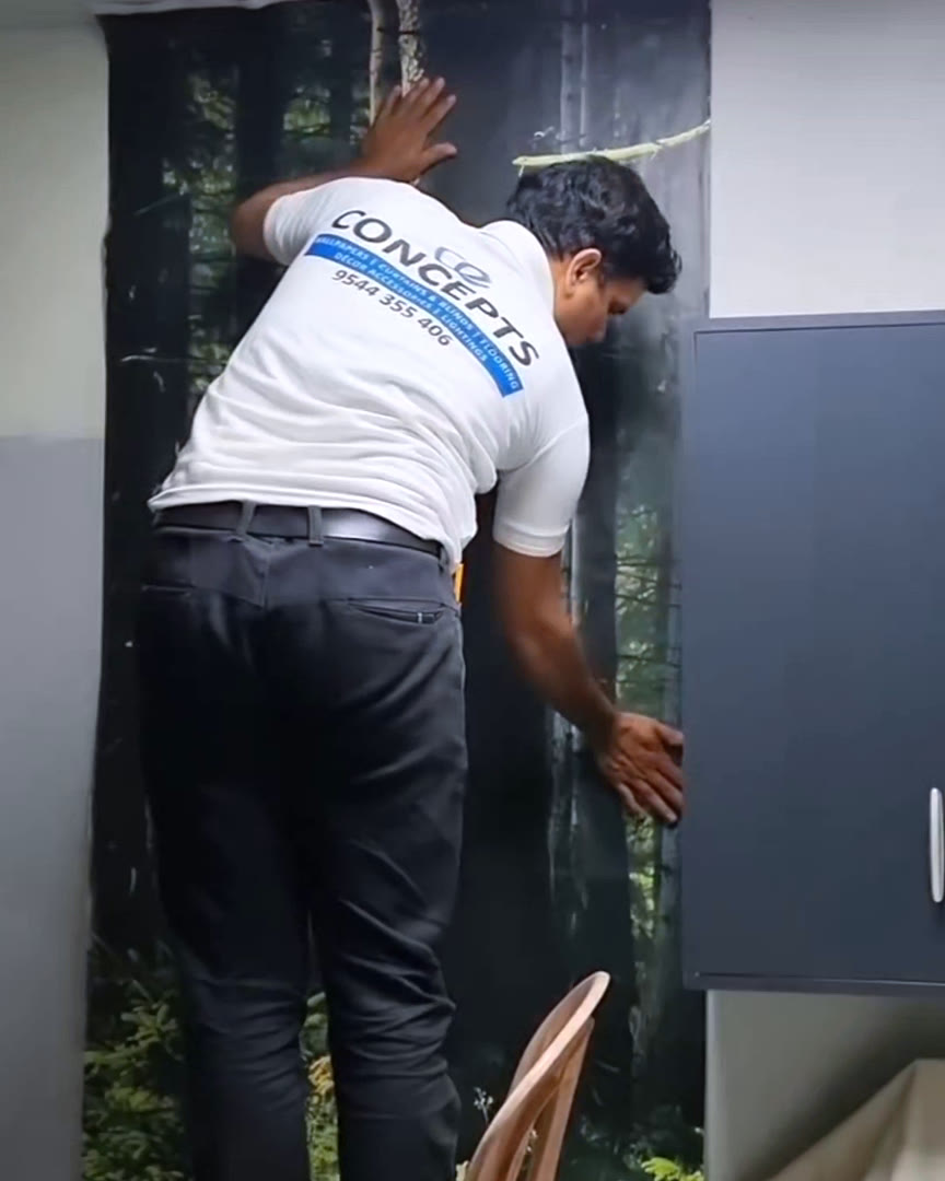 A Concepts team member fitting a custom forest wallpaper mural on site